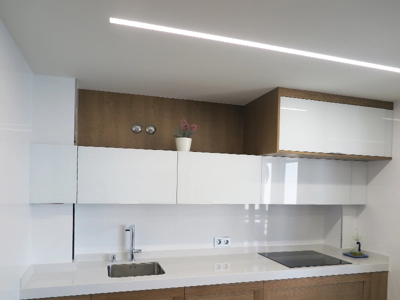 Renovación de cocina en color blanco y madera en reforma integral de piso