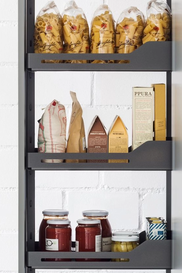 Detalle de interior de mueble columna de Senssia con estantes extraíbles con bandejas metálicas con comida organizada