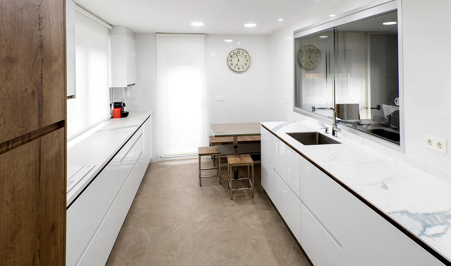 Vista de cocina moderna con carácter nórdico y frentes en paralelo con gran espacio para almacenaje.