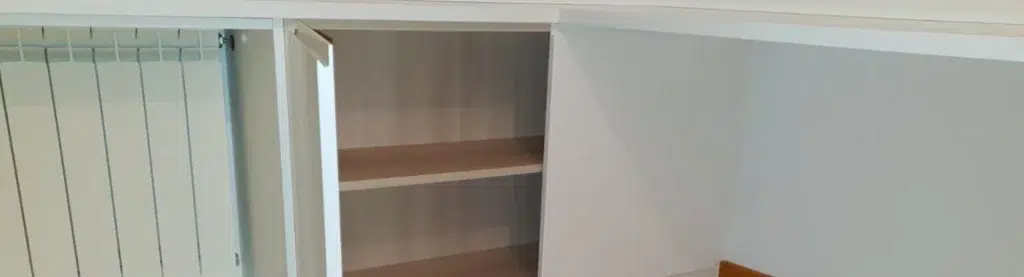 Detalle de mueble blanco con puerta abuierta hecho a medida para un espacio reducido