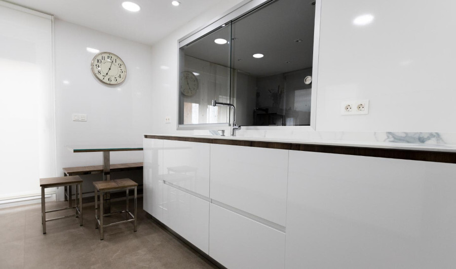 Frente de muebles bajos de cocina moderna en color blanco brillo con diseño de puerta con tirador incorporado