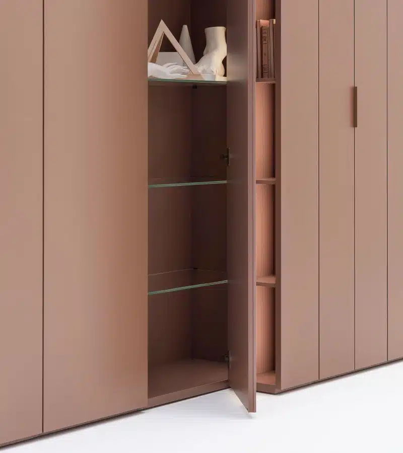 Detalle apertura puerta armario con cambio de profundidad de Caccaro en color marrón con estantes de cristal