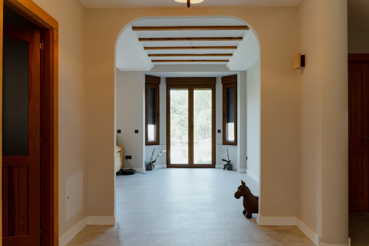 Salón con pavimento porcelánico y grandes ventanales tras la reforma integral de la vivienda.
