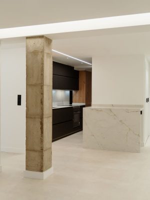 Vista general de una distribución abierta, con un pilar estructural que conserva la esencia original de la vivienda.